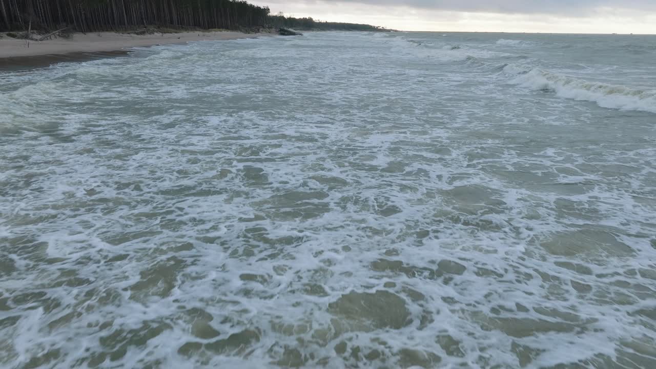 하얀 모래 해변, 흐린 날, 파도에 의해 손상된 해안 모래 언덕, 해안 침식, 기후 변화, 앞으로 나아가는 넓고 낮은 드론 샷