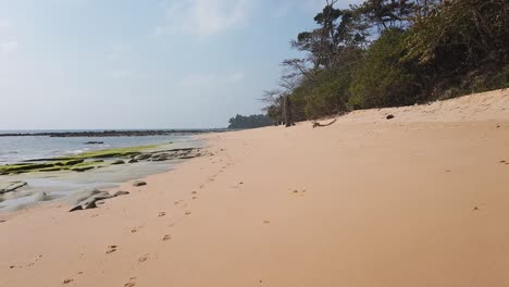 Walking-along-the-sand-of-a-remote-beach-of-an-ancient-volcanic-island-in-the-Andaman-sea