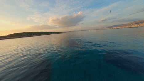 FPV---Flying-over-Kavouri-Beach-in-Vouliagmeni-at-sunset-with-seagulls