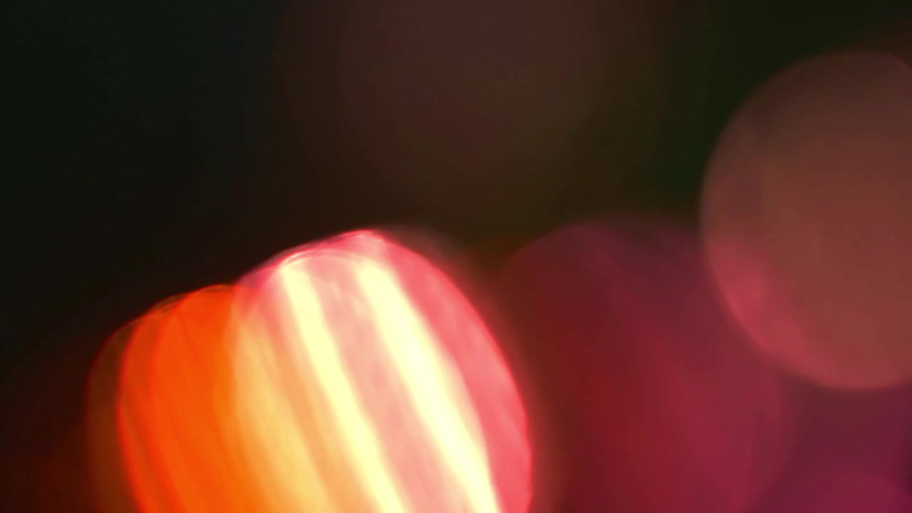 Perdite di luce astratte ed effetti bokeh su sfondo scuro.