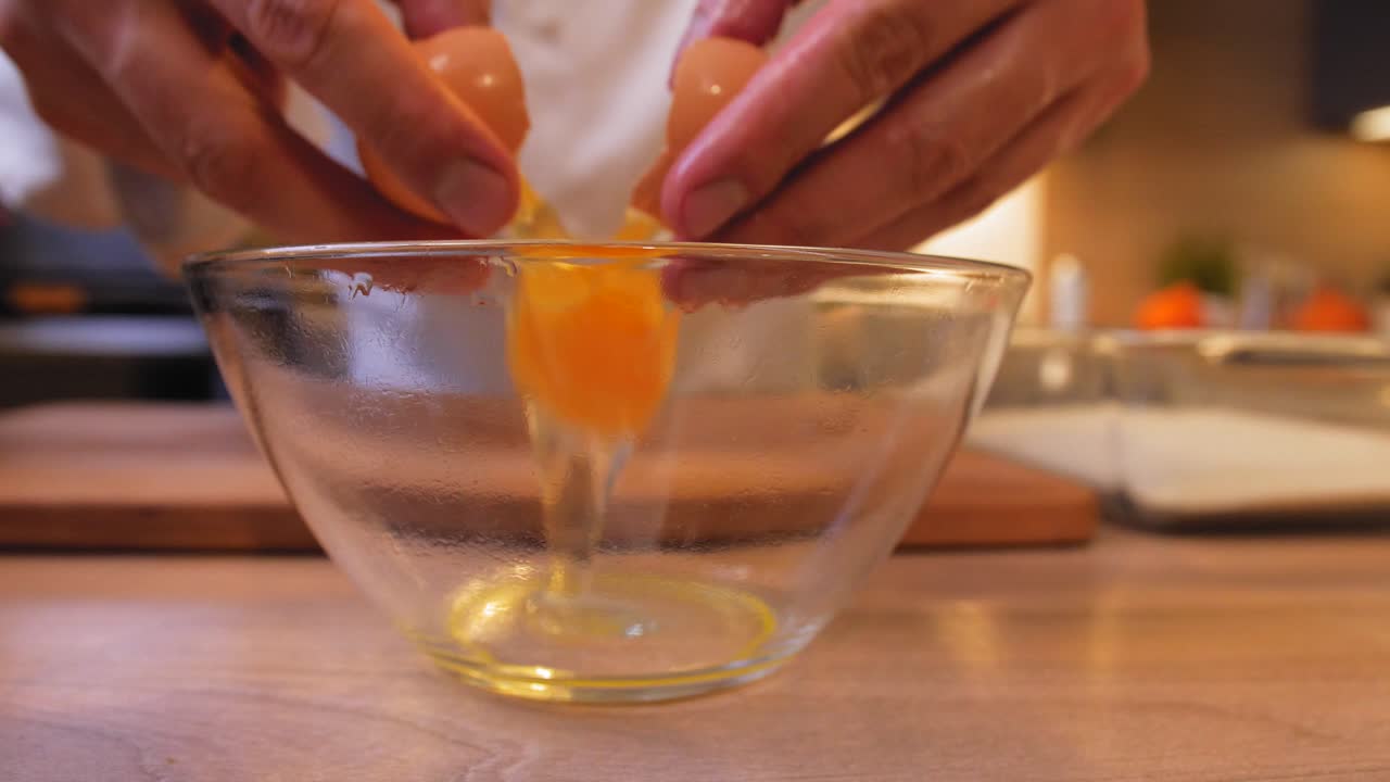 el cocinero empuja el huevo en el bol