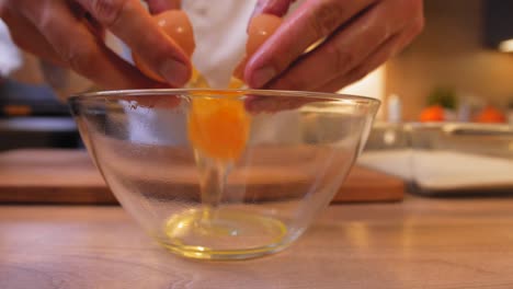 el cocinero empuja el huevo en el bol