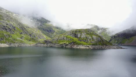 Volando-Sobre-Un-Lago-Hacia-Una-Isla-Llena-De-Vegetación-En-Las-Montañas-Noruegas