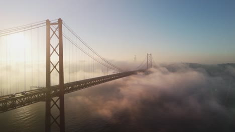 ponte 25 de abril - 25 de abril bridge shrouded by morning fog at sunrise in lisbon, portugal