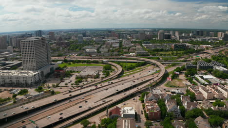 Forwards-fly-and-tilt-down-footage-of-large-busy-multi-lane-highway-interchange-in-town.-Cars-smoothly-driving-in-lanes-through-multilevel-transport-construction.-Dallas,-Texas,-US