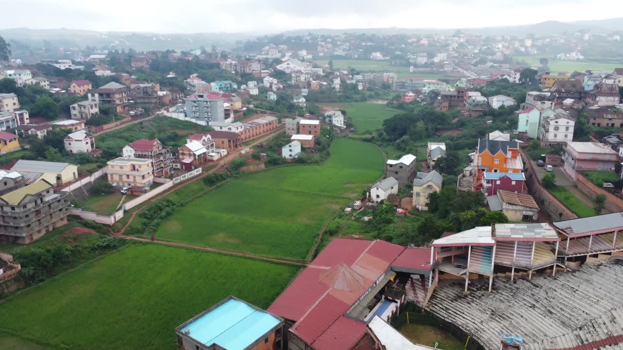 Urban farming shot shows farms within a city with buildings and farmland side-by-side in village in Madagascar, Africa