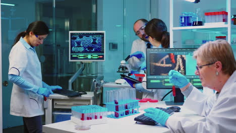 Nurse-holding-tablet-computer-and-chemist-using-microscope