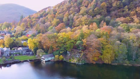 Vista-De-Drones-De-La-Colorida-Escena-Del-árbol-De-Otoño-Con-Casa-De-Botes-En-Glenridding-En-Ullswater,-Parque-Nacional-Del-Distrito-De-Los-Lagos