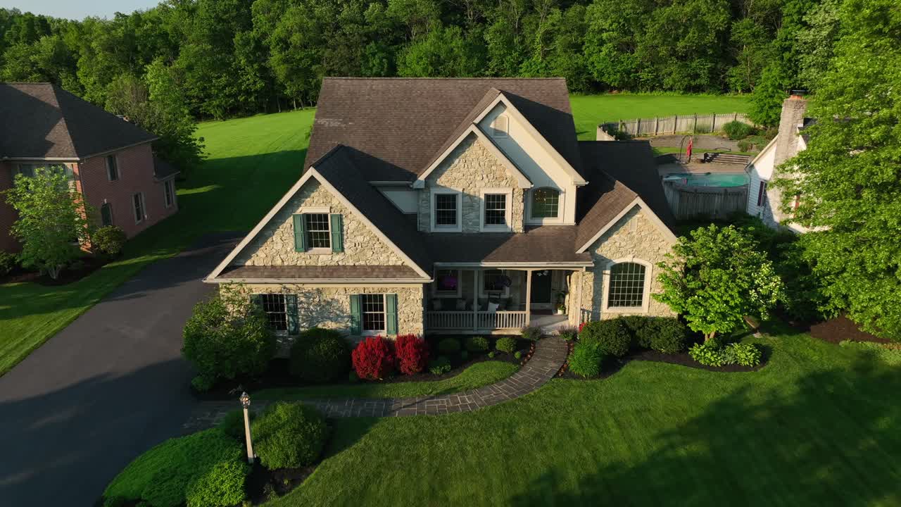 Aerial reverse shot of large American home in expensive neighborhood