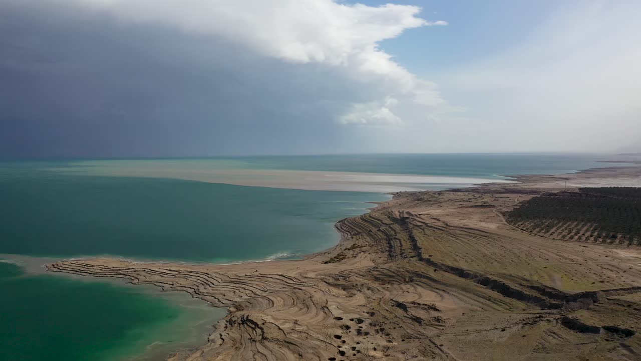 toma aérea sobre la playa del desierto del mar muerto, asombroso cielo medio nublado, israel