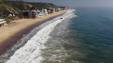 Drone-flying-above-Malibu-California-beach-neighborhood-during-summer-season