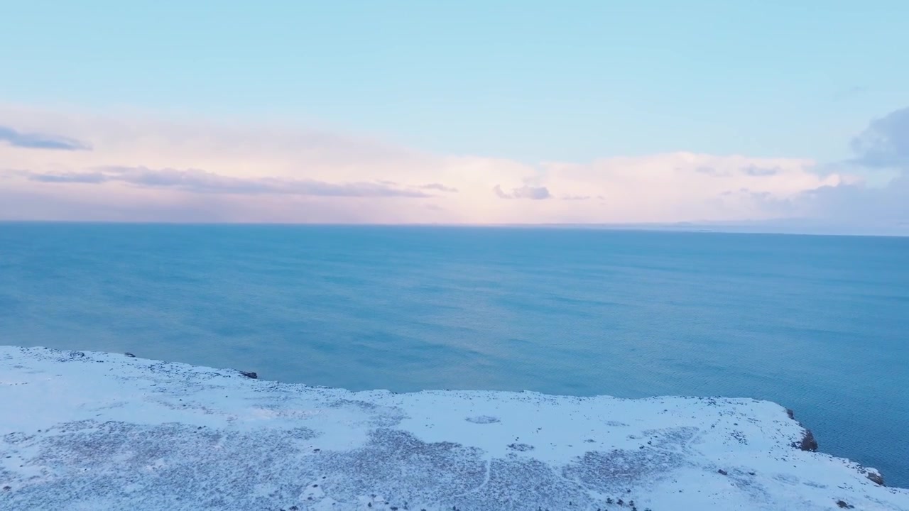 Drohne steigt über die verschneite Küste von Keflavík auf und enthüllt die isländische Atlantikküste.