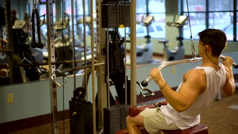 Rear-side-shot-of-young-bodybuilder-doing-lat-pulldowns-on-a-machine