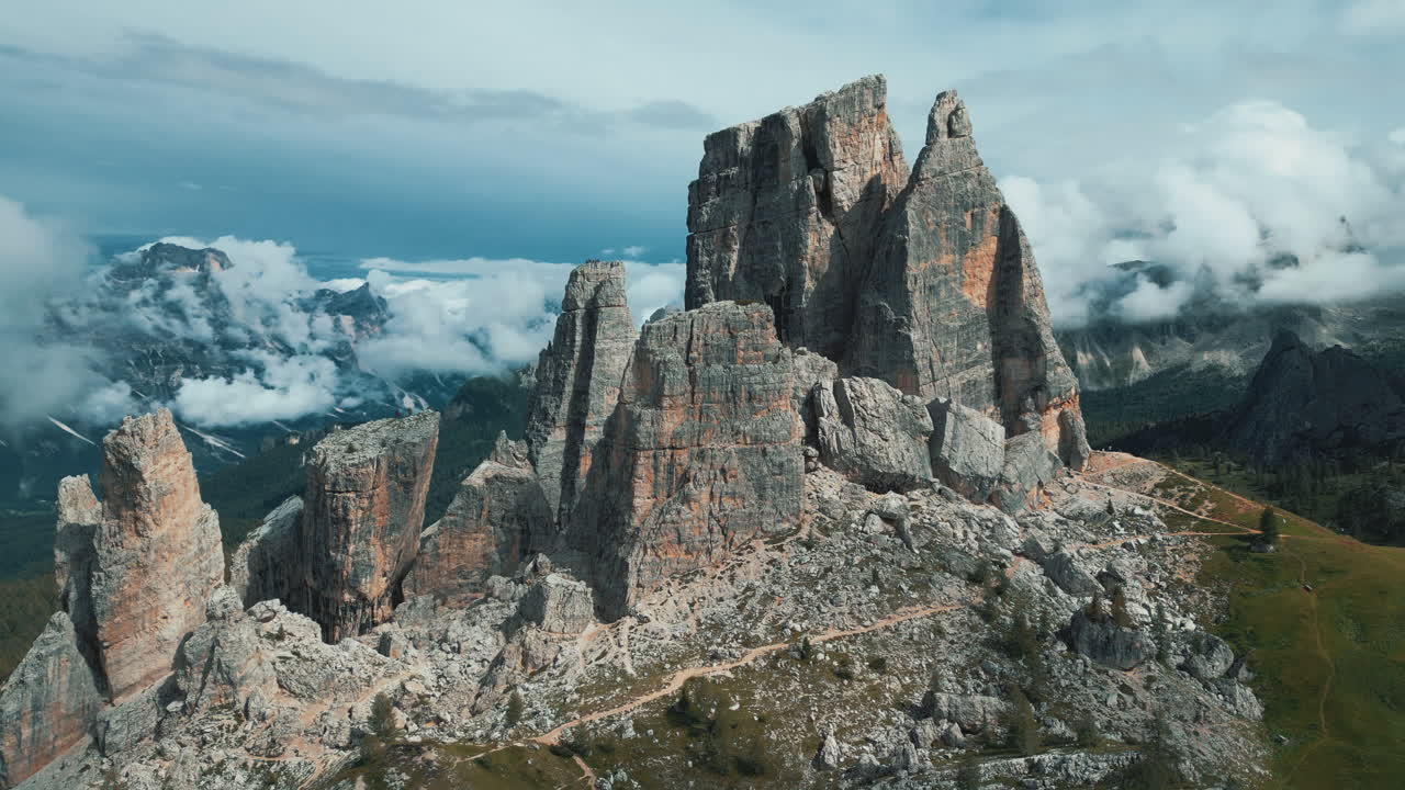 Breathtaking aerial view of Cinque Torri, a unique rock formation in the Italian Dolomites, surrounded by clouds