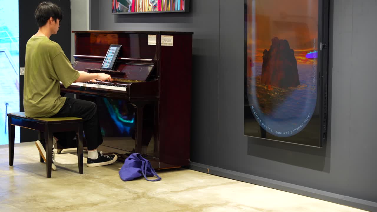 Person plays piano in a Hong Kong mall, showcasing public music and art appreciation