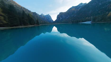 Volando-Sobre-Las-Hermosas-Y-Tranquilas-Aguas-De-Laggo-Di-Dobiacco,-Dolomitas,-Italia-Durante-El-Amanecer---Toma-Aérea