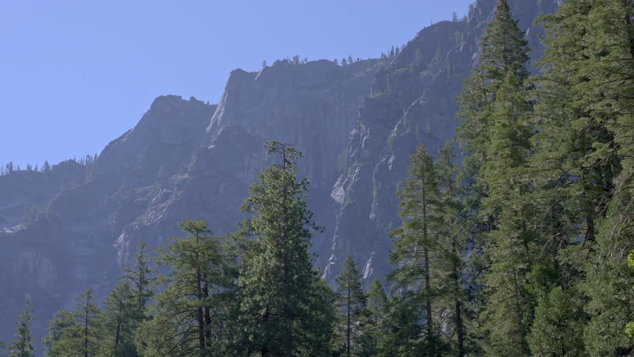 A 4K static frame shows Yosemite’s jagged granite cliff rising straight up, all sharp ridges and deep cracks etched in gray stone
