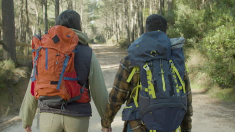 young couple with backpacks hiking together