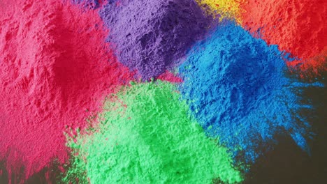 Video-of-close-up-of-multi-coloured-powders-with-copy-space-on-black-background