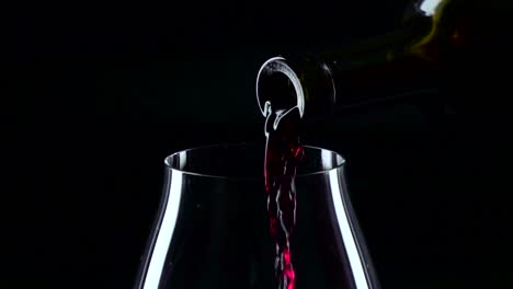 red wine pouring from bottle into glass