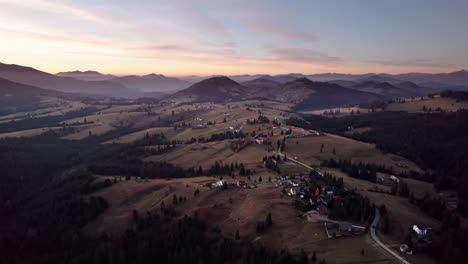 Vista-Aérea-Del-Pintoresco-Pueblo-En-Una-Colina-Con-Bosque-De-Pinos-Al-Atardecer