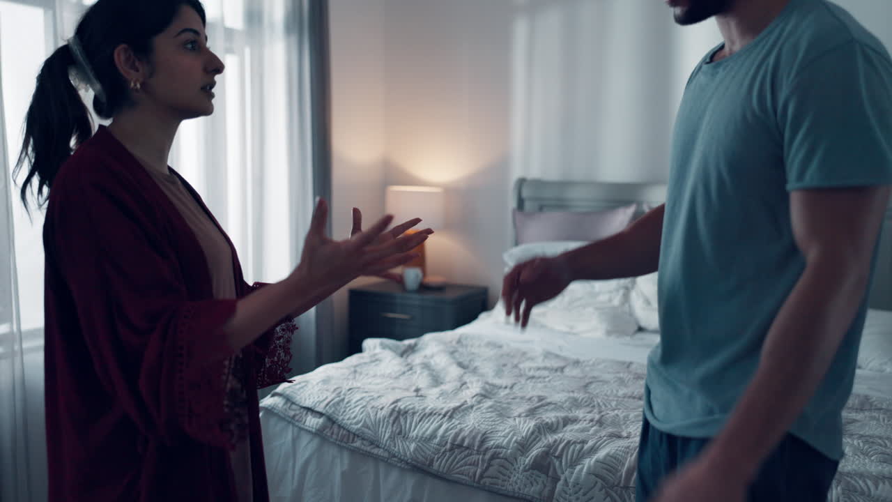 una pareja discutiendo en el dormitorio.