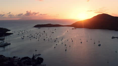 aerial shot of sunset in english harbor in antigua, caribbean with views of yachts, sailboats, marina, bay and cliffs