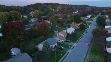 autumn trees and houses in american neighborhood at dusk