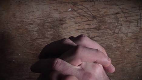 close-up of hand gestures on wooden surface expressing contempt