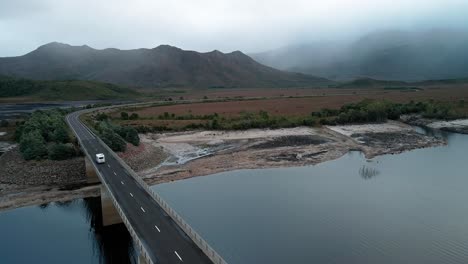 aerial drone backward moving shot over bradshaw bridge that spans over artificial lake burbury along the western coast of tasmania during evening time