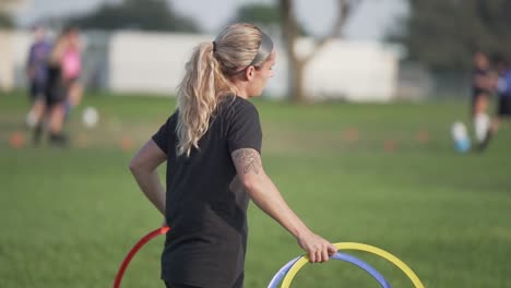 female soccer coach carrying colored training rings