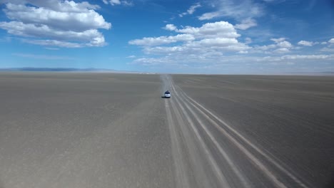 una toma aérea de un avión no tripulado de una furgoneta en el desierto.