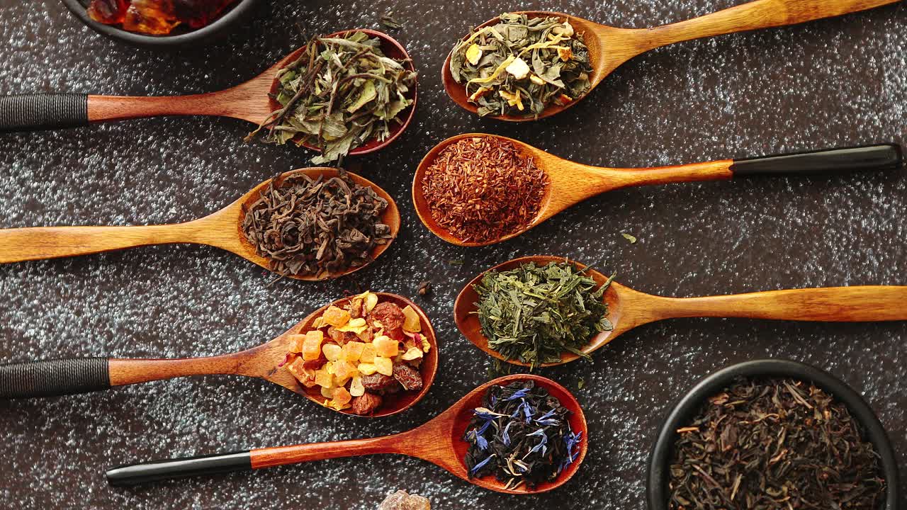 cucharas con diferentes tipos de hojas de té secas