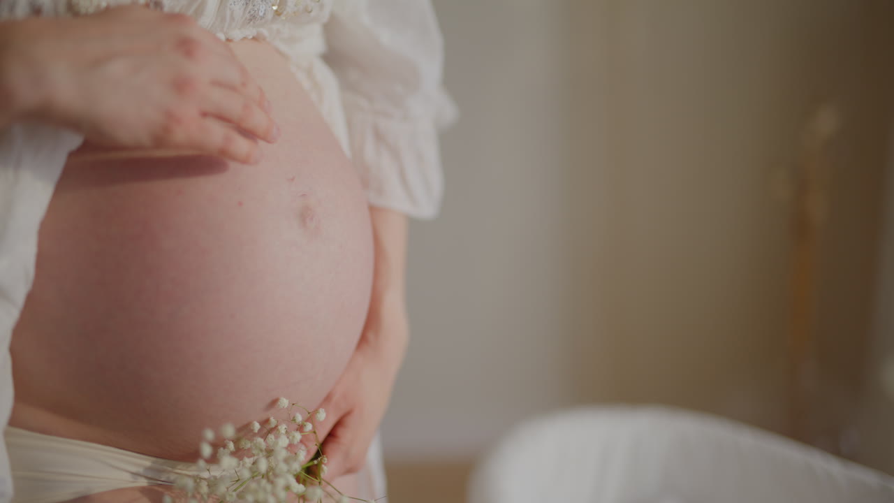 Primo piano di donna incinta che accarezza dolcemente la pancia