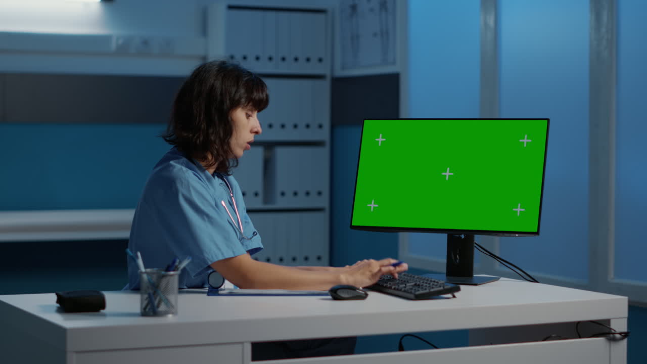 Healthcare professional working on a computer with a green screen
