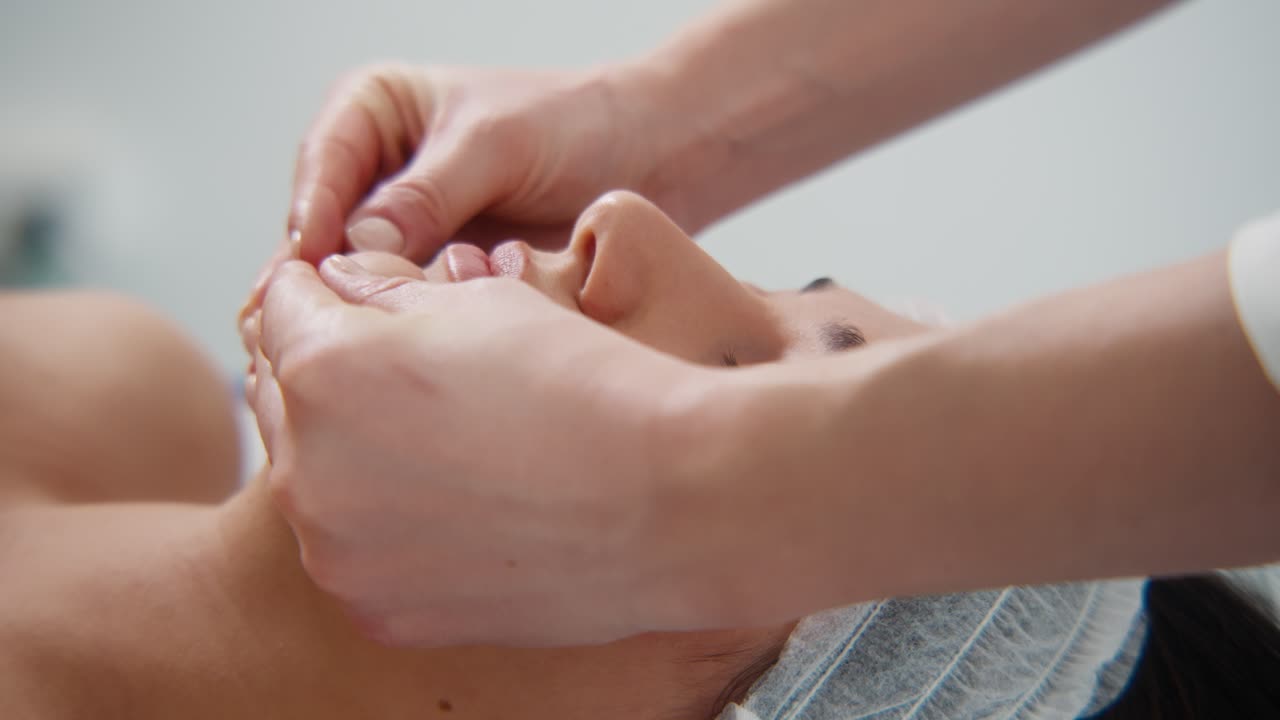 Primo piano di siero viso applicato sulla guancia di una donna con un contagocce durante una sessione professionale di cura della pelle in una spa.