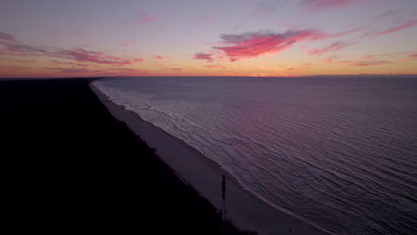 Vista-Aérea-De-Los-Cielos-Anaranjados-De-La-Puesta-De-Sol-Sobre-La-Playa-De-Krynica-Morska,-Polonia