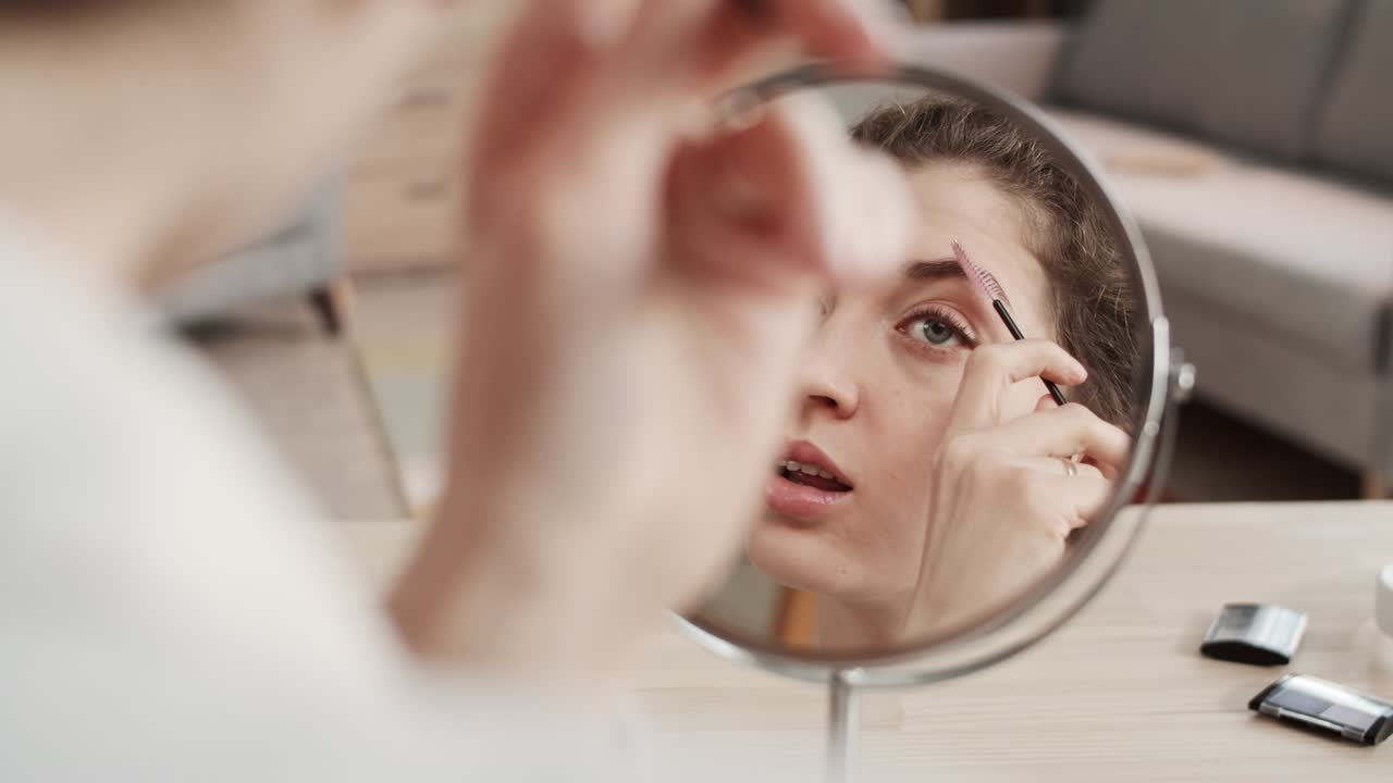 Woman Looking in Mirror Doing Makeup