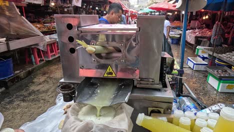 machine extracting juice from sugar cane stalks