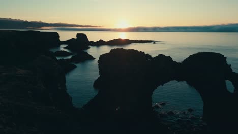 Incredible-drone-aerial-of-coral-sea-arch-and-coastal-lands-during-sunset