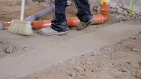 Trabajador-Barriendo-Un-Piso-Polvoriento-Con-Tuberías-De-Aguas-Residuales-En-El-área-Del-Piso-Almacen-De-Video