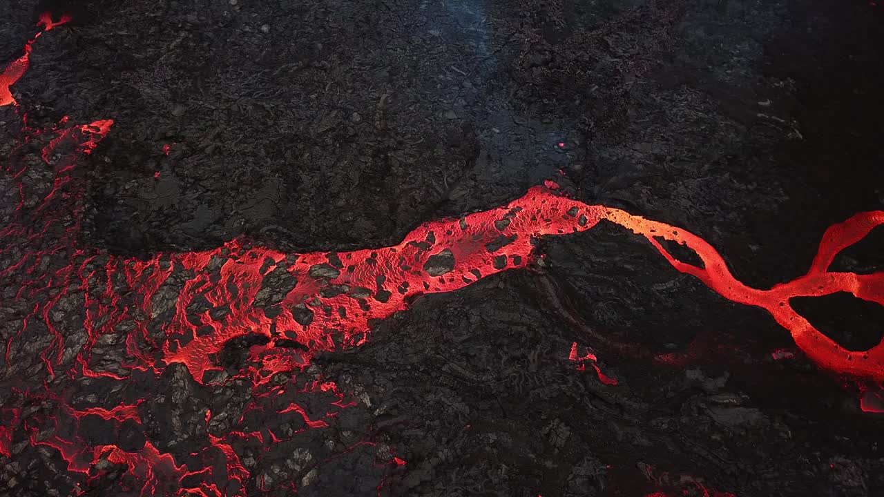 vista aérea sobre un río de lava que fluye a través del valle de meradalir, islandia, saliendo del volcán fagradalsfjall