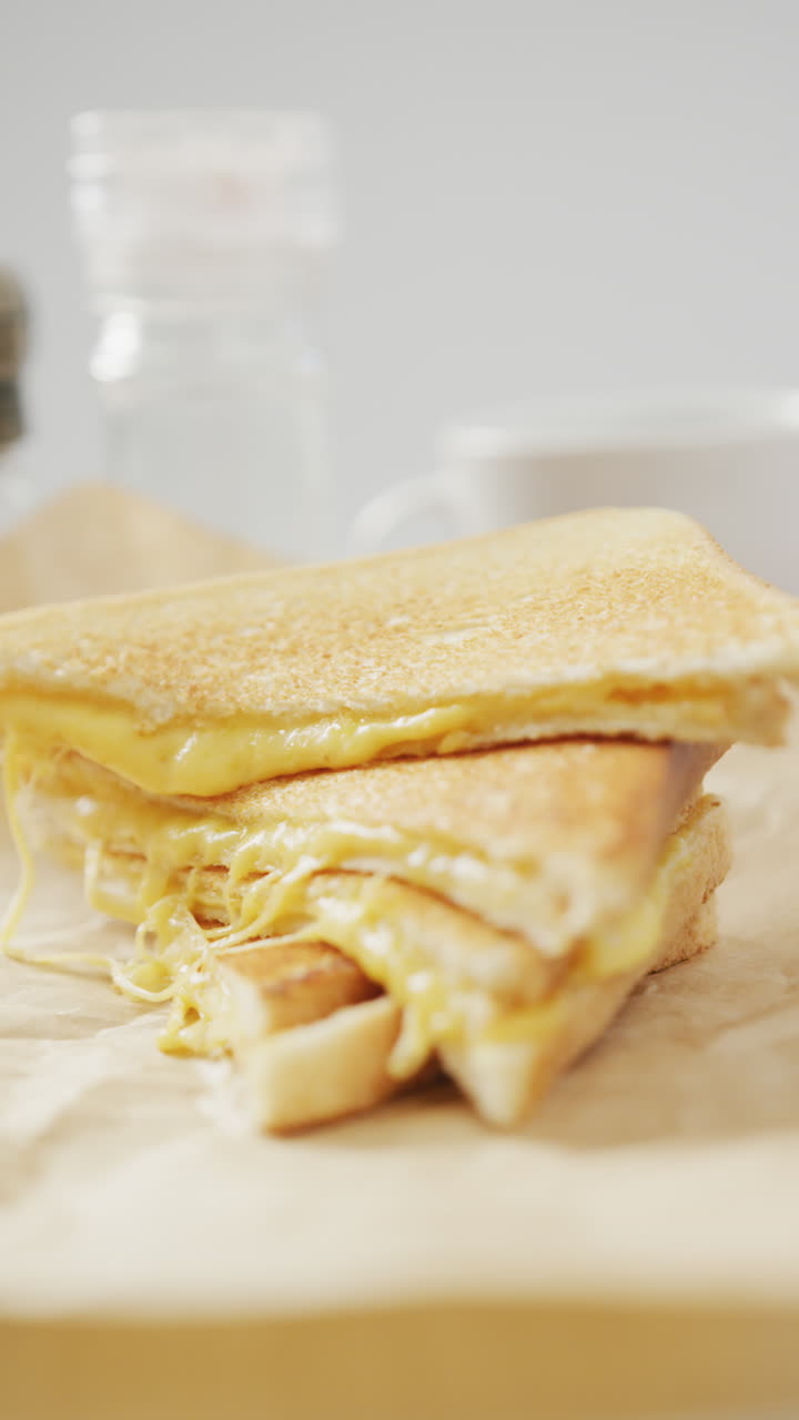 회색 배경에 녹은 치즈와 함께 신선한 토스트의 클로즈업의 수직 비디오