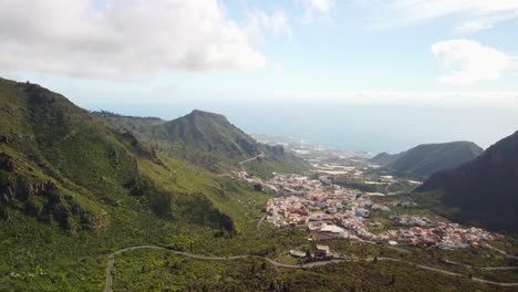 Curvy-road-leading-to-coastal-town-of-Tenerife,-aerial-drone-view