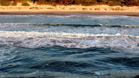 Golden-sunlight-reflecting-on-tumultuous-ocean-waves,-The-sea's-surface-glistening-at-sunset