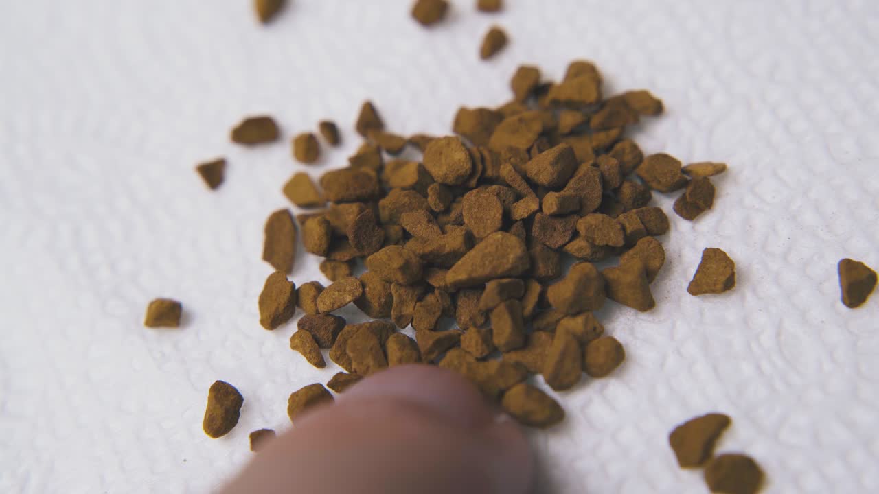 ein mann legt instantkaffeegranulate auf eine papierserviette