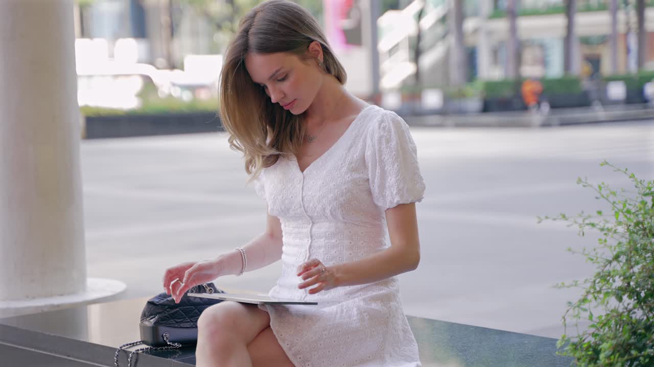 женщина использует планшет на городской улице