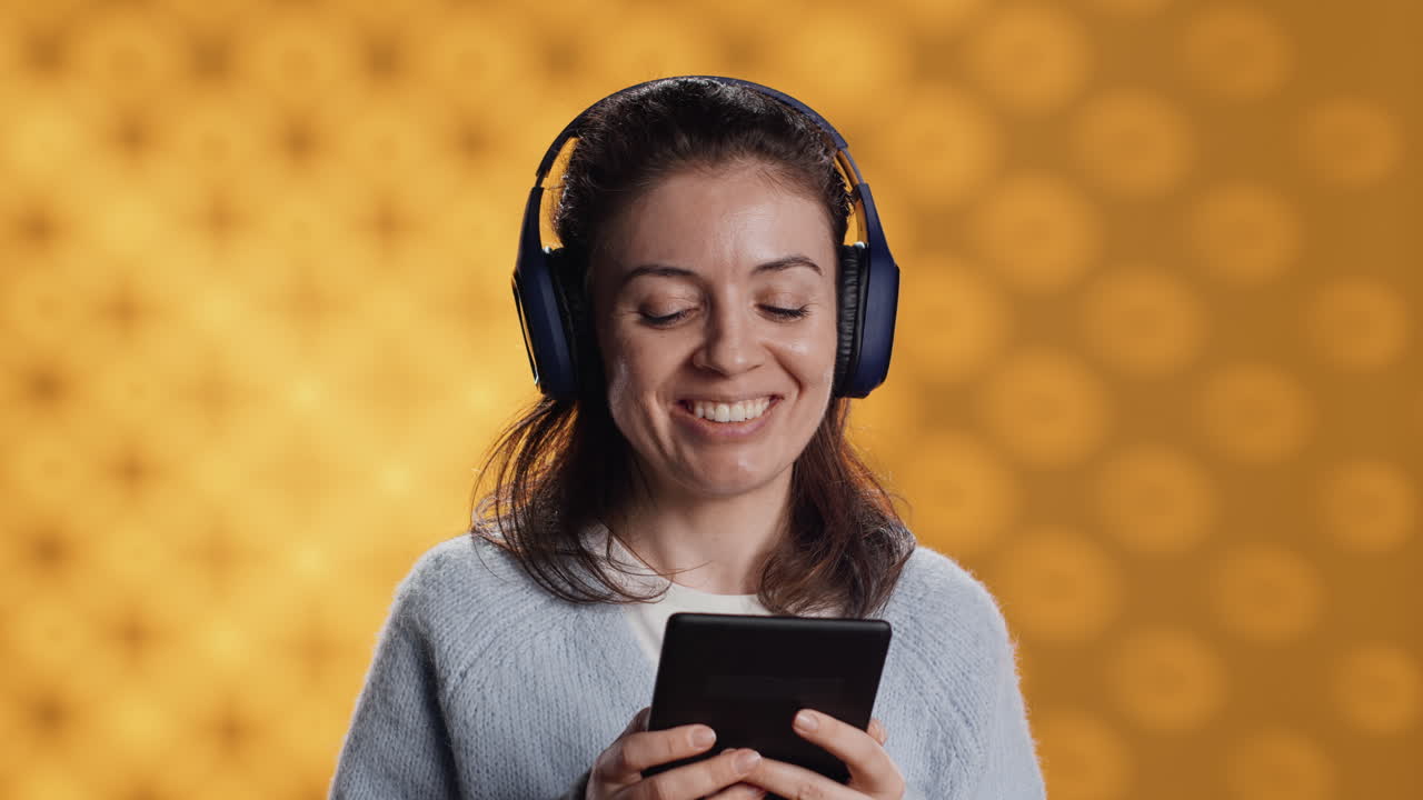 Doppiatore che sorride mentre legge un ebook, interpretando un personaggio orgoglioso e sfacciato.