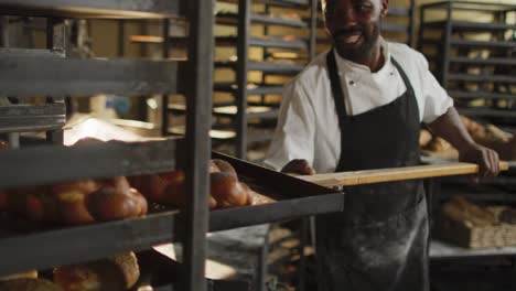 animation of happy african american male baker holding wooden spatula with challah
