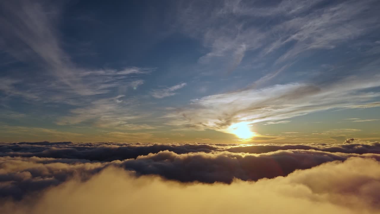 Vista aerea cinematografica di un'alba dorata sopra le nuvole con nebbia e cielo blu. Perfetta per progetti di viaggio, ispirazione, cinematografia e natura